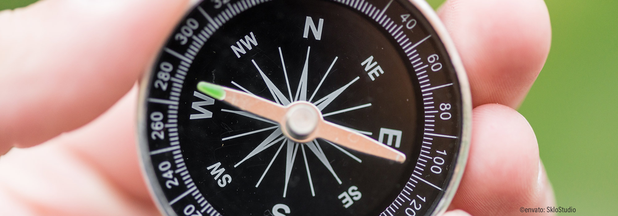 Nahaufnahme eines schwarzen Kompasses in der Hand zeigt Orientierung und Richtung - Impulsvortrag Auf Kurs bleiben professionelle Selbstreflexion Beratungsalltag