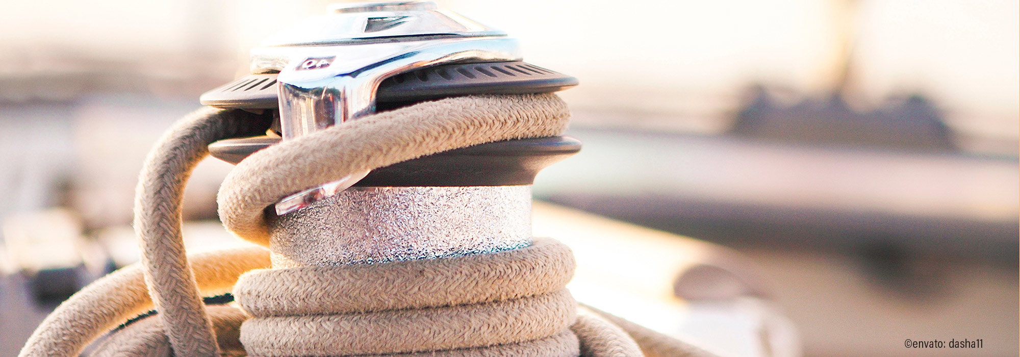 Dickes Schiffsseil um Poller gewickelt, mit Boot im Hintergrund - NEBE Impulsvortrag Leinen los Implementierung von Beratungsimpulsen ins eigene Team