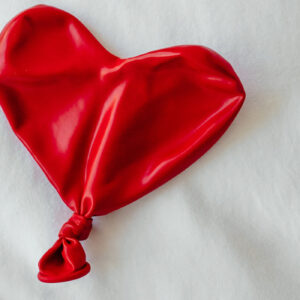 Zusammengefallener roter Luftballon in Herzform auf weißem Untergrund - Fachmodul Märchen der Gefühllosigkeit Emotionen soziale Beziehungen Spektrum
