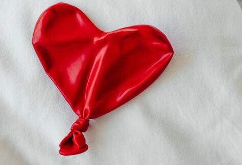 Zusammengefallener roter Luftballon in Herzform auf weißem Untergrund - Fachmodul Märchen der Gefühllosigkeit Emotionen soziale Beziehungen Spektrum