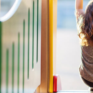 Kind von hinten sitzt auf Spielplatzrutsche und blickt hinaus - NEAS Impuls Neues Kind und ich weiß kaum was